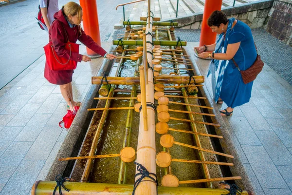 Kyoto, Japonya - 05 Temmuz 2017: Fushimi Inari tapınak Kyoto Pavyonu kimliği belirsiz kişi onların el el yıkama yıkamak