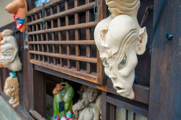 KYOTO, JAPAN - JULY 05, 2017: Halloween masks hanging ina wooden wall in outdoors, located in the center of Gion street of Kyoto, Japan