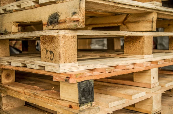 Existencias exteriores de paletas estándar de madera fabricadas antiguas almacenadas en pilones —  Fotos de Stock