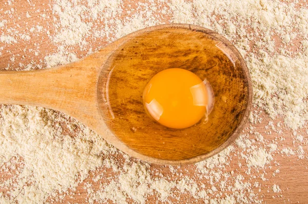 Открытое яйцо на деревянной ложке — стоковое фото