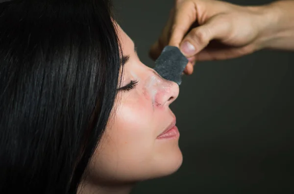 Jonge vrouw schoonheid opstijgen een zwarte neus masker op schone huid uit zwarte vlekken — Stockfoto