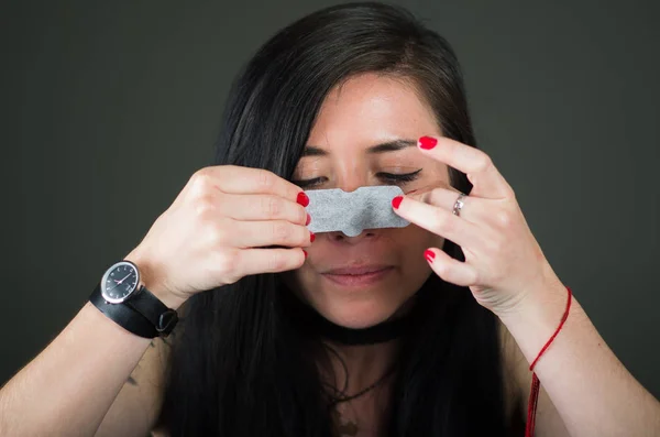 Schönheit junge Frau trägt eine schwarze Nasenmaske, um die Haut von schwarzen Flecken zu reinigen — Stockfoto