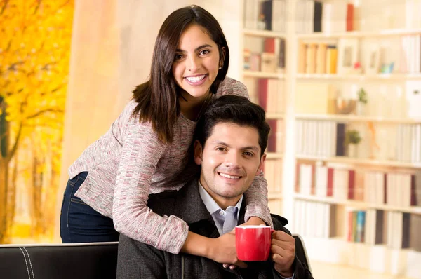 Beautiful young couple in love, woman embracing his boyfriend in a office background — Stock Photo, Image