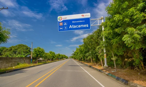 Esmeraldas, Ecuador - March 16, 2016: Paved road in the coast, with informative sign, surrounded with abundat vegetation in a sunny day in the Ecuadorian coasts — Stock Photo, Image