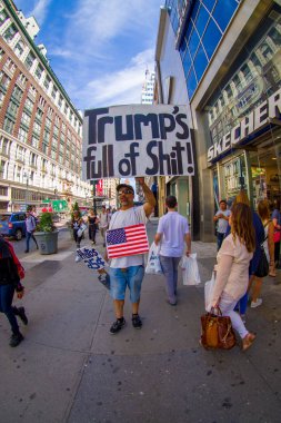New York, ABD - 22 Haziran 2017: bir işaret onların elinde tutan evsiz bir adam ile bir güzel New York City New York City ABD'de muhteşem binalarının ve gökdelenlerin ile yürüyüş tanımlanamayan kişi 