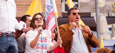Quito, Ekvator - 7 Nisan 2016: Kimliği belirsiz kişiler Ekvador ve beyaz mikrofon konuşmak ve Başkan adayı Guillermo Kement ve anti sırasında gazeteciler destekleyen bayrakları