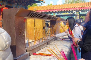 Hong Kong, Çin - 22 Ocak 2017: Dua, Hong Kong, Çin için incenses Wong Tai Sin Budist tapınağı içinde yanan kimliği belirsiz insanlar