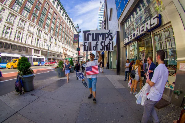 NUEVA YORK, EE.UU. - 22 de junio de 2017: Personas no identificadas caminando por una hermosa ciudad de Nueva York con rascacielos y magníficos edificios en la ciudad de Nueva York, EE.UU., con un hombre sin hogar sosteniendo en sus manos un cartel —  Fotos de Stock