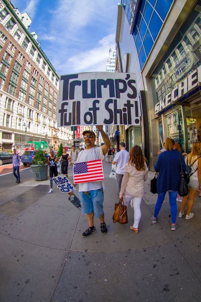 NEW YORK, États-Unis - 22 JUIN 2017 : Des personnes non identifiées marchant dans une belle ville de New York avec des gratte-ciel et de magnifiques bâtiments à New York aux États-Unis, avec un sans-abri tenant dans leurs mains un signe — Photo