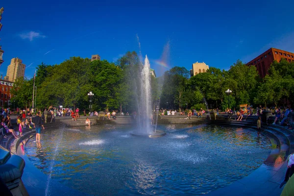Nowy Jork - 22 lipca 2017: Niezidentyfikowanych ludzi korzystających letni dzień w Washington Square Park, wewnątrz fontanny, z mała tęcza w środku fontanny w Nowym Jorku, rybie oko — Zdjęcie stockowe