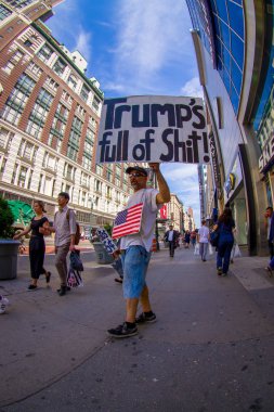 New York, ABD - 22 Haziran 2017: bir işaret onların elinde tutan evsiz bir adam ile bir güzel New York City New York City ABD'de muhteşem binalarının ve gökdelenlerin ile yürüyüş tanımlanamayan kişi 