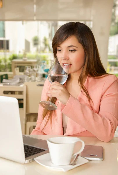 Primo piano di una giovane bella donna d'affari sorridente che lavora e beve un bicchiere d'acqua. Concetto aziendale — Foto Stock