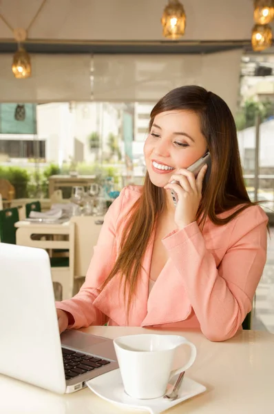 Primo piano di una giovane bella donna d'affari sorridente che indossa una giacca rosa e usa il suo cellulare per fare una chiamata. Concetto aziendale — Foto Stock