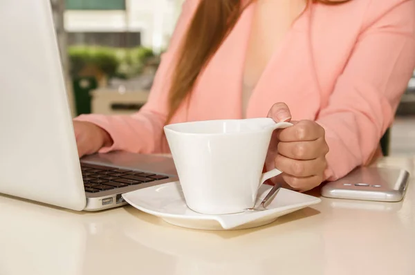 Nahaufnahme einer Geschäftsfrau, die Hand arbeitet und mit einer Hand eine Tasse Kaffee hält. Geschäftskonzept — Stockfoto