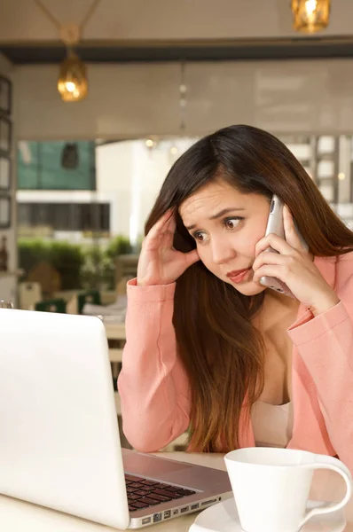 Primer plano de una joven empresaria estresada en la oficina mientras usa un teléfono celular con una cara preocupada. Concepto empresarial — Foto de Stock