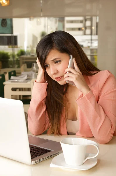 Close up de uma jovem empresária estressada no escritório, enquanto ela está usando um celular com um rosto louco. Conceito de negócio — Fotografia de Stock