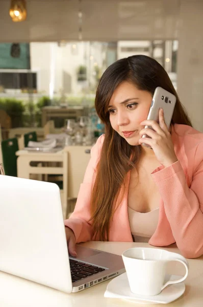 Närbild av en ung affärskvinna stressad på kontoret medan hon använder en mobiltelefon med galna ansikte. Affärsidé — Stockfoto