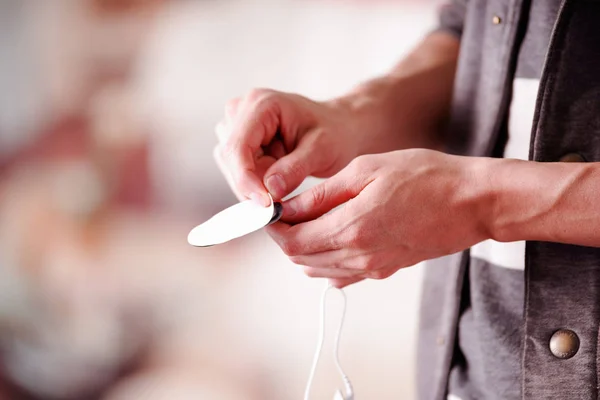 Primer plano de un hombre de mano sacando una cinta adhesiva de los electrodos del electroestimulador en un fondo borroso — Foto de Stock