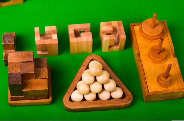Assortiti rompicapo in legno o puzzle in legno su sfondo verde — Foto Stock