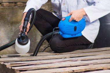 Onun tutan el ulağı el boyama sprey, sprey topu açık havada bulunan Ahşap yapı boya inşaat işçisi