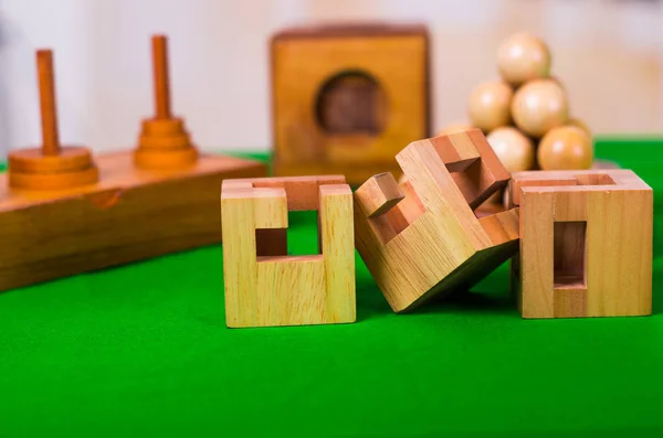 Drewniany klocek łamigłówka logiczna na zielony stół w niewyraźne tło — Zdjęcie stockowe