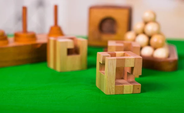 Puzzle casse-tête bloc en bois sur table verte dans un fond flou — Photo