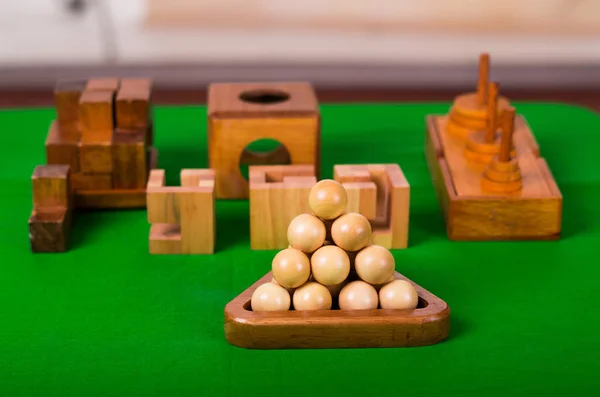 Assorted wooden brain teaser or wooden puzzles on green background