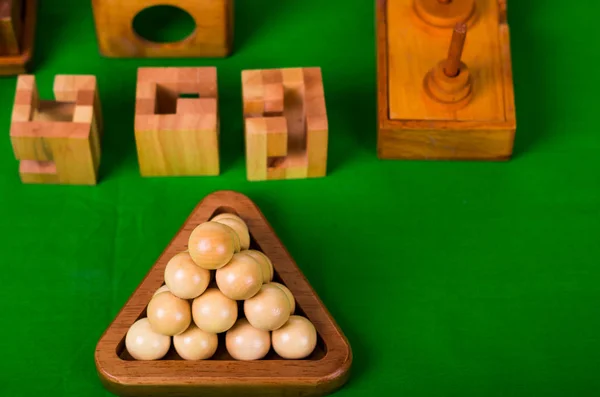 Assortiment de casse-tête en bois ou puzzles en bois sur fond vert — Photo