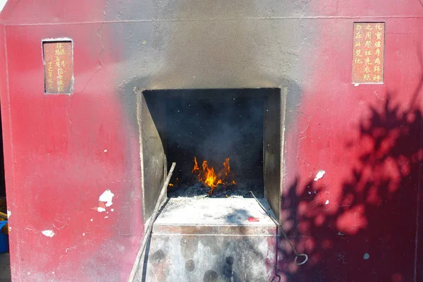 Ein roter rustikaler Ofen im Freien, mit Feuer drinnen im Tsz-wan-Tempel, in ong kong — Stockfoto