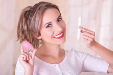 Arka plan bulanık bir adet kaba genç güzel gülümseyen kadın adet pamuk tampon bir elinde ve onunla birlikte diğer elini tutarak yakın çekim
