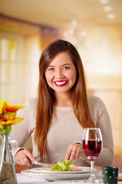 Retrato de una hermosa mujer elegante con el pelo largo comiendo sola en un restaurante en un fondo borroso —  Fotos de Stock