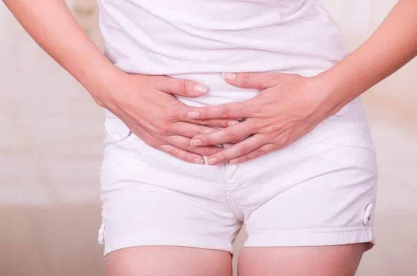 Junge Frau berührt ihren Bauch, leidet unter Menstruationsbeschwerden, weibliches Gesundheitskonzept — Stockfoto