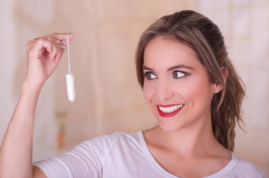 Seyir ve bir adet pamuk tampon bulanık bir arka planda tutan genç güzel gülümseyen kadın