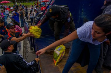 Quito, Ekvator - Nisan, 17, 2016: Kalabalık sahil deprem ölüm için Afet Yardım gıda, giyim, ilaç ve su sağlayan insan Quito