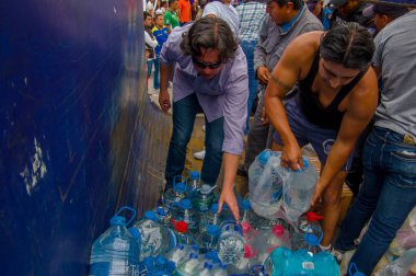 Quito, Ekvator - Nisan, 17, 2016: Su kıyılarında deprem kurtulanlar için sağlayan bir araç tanımlanamayan kişi