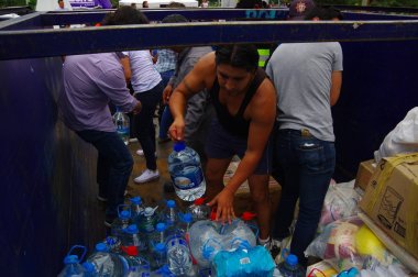 Quito, Ekvator - Nisan, 17, 2016: Su kıyılarında deprem kurtulanlar için sağlayan bir araç tanımlanamayan kişi