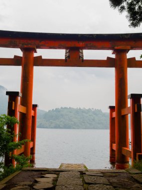 Parlak kırmızı yakın kapı'nin ortaklaşa Gölü, caldera arka planda dağlar ile sular altında. Hakone Tapınak, Kanagawa İli, Japonya