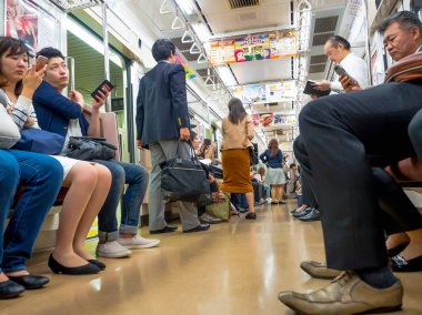 Tokyo, Japonya - 2 Ocak 2016. Tokyo, Japonya'nın bir Yamanote tren oturan insanlar. Japonya demiryolu sistemi dakiklik ve güvenliği için yüksek bir üne sahiptir