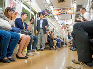 Tokyo, Japonya - 2 Ocak 2016. Tokyo, Japonya'nın bir Yamanote tren oturan insanlar. Japonya demiryolu sistemi dakiklik ve güvenliği için yüksek bir üne sahiptir