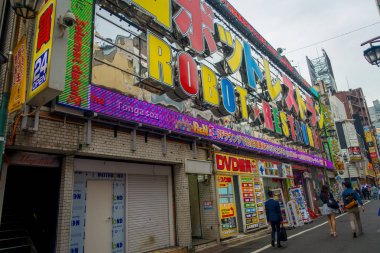 Tokyo, Japonya Haziran 28-2017: kimliği belirsiz kişi Kabukicho kırmızı ışıklar bulunan bir robot Restoran dışında yürüme, Tokyo'da bulunan büyük binaları ve reklamlar, çevreleyen
