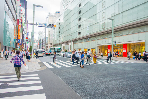 ТОКИО, ЯПОНИЯ-28 июня 2017: Неизвестные люди переходят улицу через зебру в электрическом городе Гиндза, в Токио
