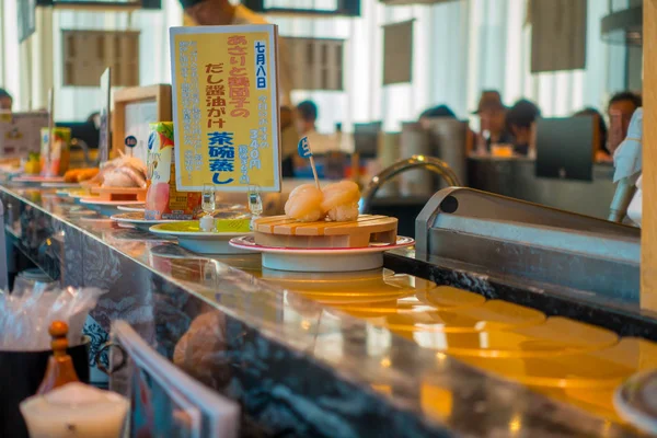 Tokyo, Japan -28 juni 2017: Close-up van geassorteerde japanesse voedsel over een tafel, binnenkant van een kaitenzushi conveyor belt sushi restaurant in Tokyo — Stockfoto