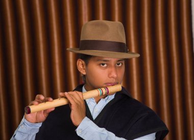 Young man from Otavalo, Ecuador, playing the quena flute clipart