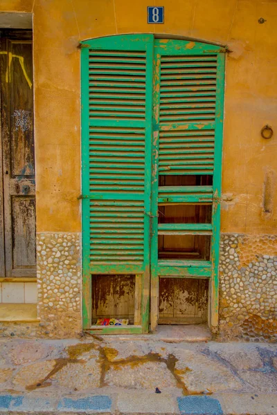 PORT D ANDRATX, ESPAÑA - 18 AGOSTO 2017: Hermosa vista de la pequeña puerta verde vieja en una pared dañada, en la ciudad de Port D Andratx, situada en las islas baleáricas de Mallorca, España — Foto de Stock