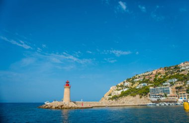 Mallorca Balear Adaları, bir deniz feneri ve ufuk dağda bazı binalarda muhteşem mavi su ve İspanya güzel bir mavi gökyüzü ile güzel manzara