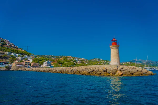 Belle vue sur les îles baléares de Majorque, avec un phare et quelques bâtiments dans la montagne à l'horizon, avec de magnifiques eaux bleues et un beau ciel bleu, en Espagne — Photo