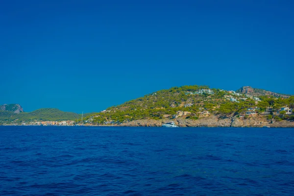 Bella vista sulle isole Baleari di Maiorca, con alcuni edifici in montagna all'orizzonte, con splendida acqua blu e un bel cielo blu, in Spagna — Foto Stock