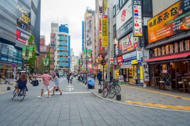 Tokyo, Japonya Haziran 28-2017: kimliği belirsiz kişi, ünlü Kabukicho kırmızı ışıklar bölgesinde yürüyüş Tokyo'da bulunan büyük binaları ve reklamlar, çevreleyen