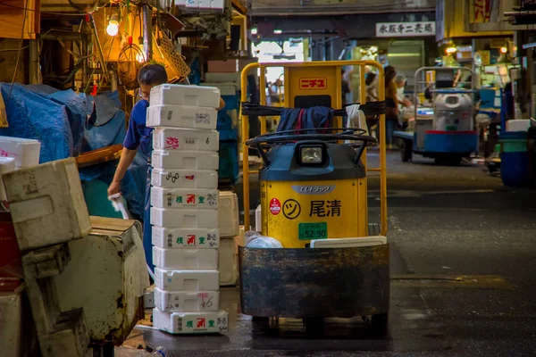 일본 도쿄, 6 월 28-2017: 일본 도쿄, 츠 키 지 시장에서에서 생선 시장 츠 키 지의 내부 작은 화물 노란색 기계, 정체 불명된 남자는 가장 큰 도매 물고기와 해산물 시장에는 — 스톡 사진