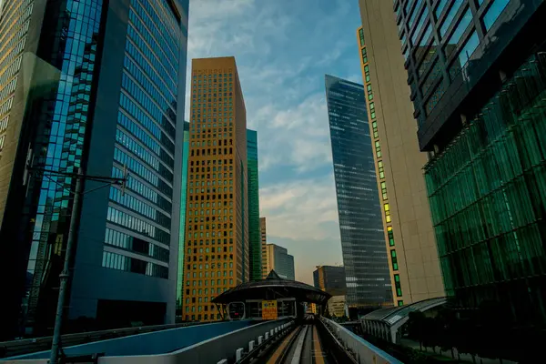 TOKYO, JAPÃO JUNHO 28 - 2017: Cenário de um trem viajando no trilho elevado da Linha Yurikamome em Odaiba, Minato, Tóquio, sob céu azul claro e ensolarado — Fotografia de Stock